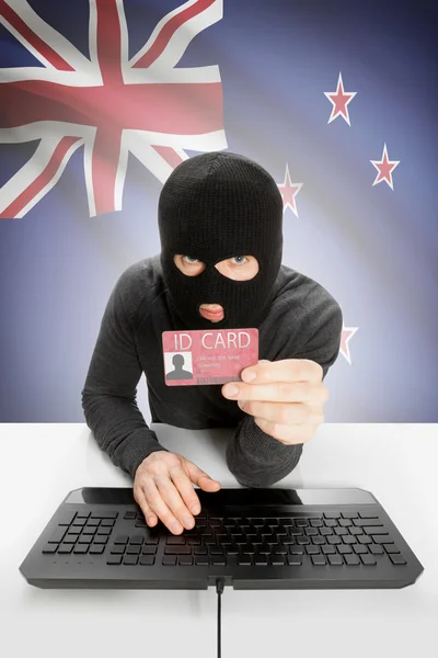 Хакер с флагом на заднем плане с удостоверением личности в руке - Новая Зеландия — стоковое фото