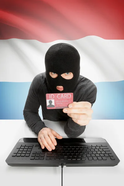 Hacker com bandeira no fundo segurando cartão de identificação na mão - Luxemburgo — Fotografia de Stock