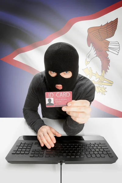 Hacker with flag on background holding ID card in hand - American Samoa — Stock Photo, Image