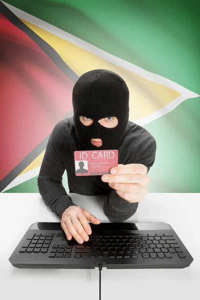 Hacker con bandera en el fondo con tarjeta de identificación en la mano - Guyana —  Fotos de Stock