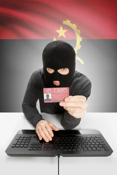 Hacker with flag on background holding ID card in hand - Angola — Stock Photo, Image