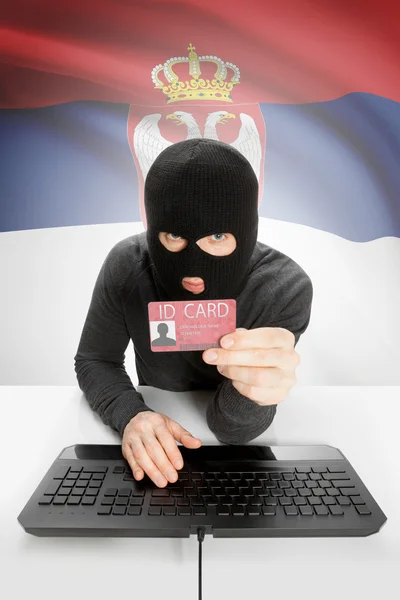 Hacker with flag on background holding ID card in hand - Serbia — Stock Photo, Image