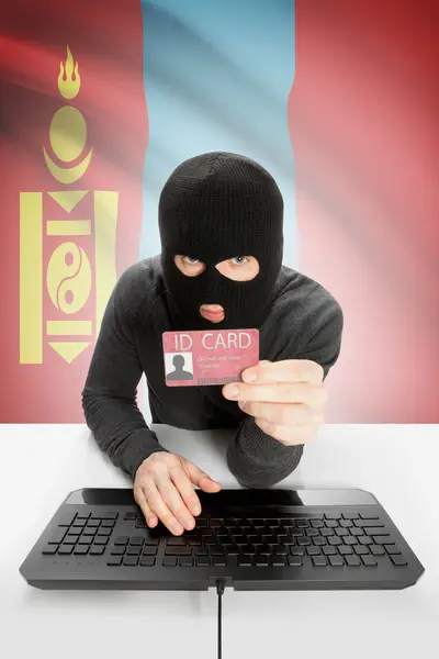 Hacker with flag on background holding ID card in hand - Mongolia — Stock Photo, Image