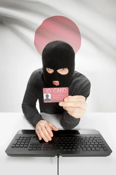 Hacker with flag on background holding ID card in hand - Japan — Stock Photo, Image