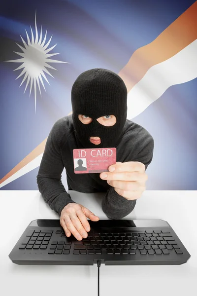 Hacker with flag on background holding ID card in hand - Marshall Islands — Stock Photo, Image