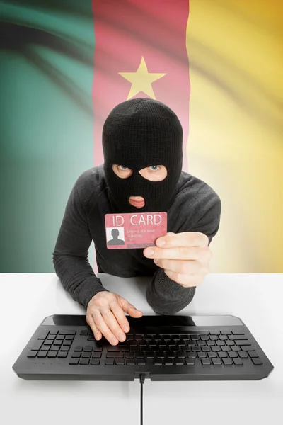 Hacker with flag on background holding ID card in hand - Cameroon — Stock Photo, Image