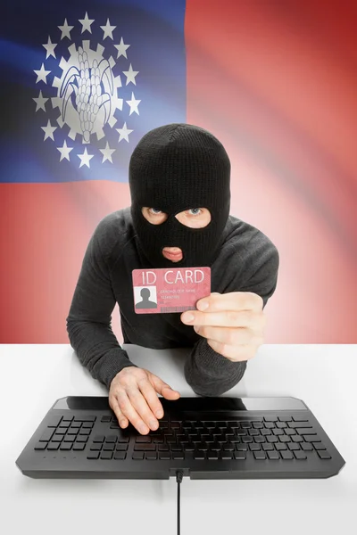 Hacker with flag on background holding ID card in hand - Burma — Stock Photo, Image