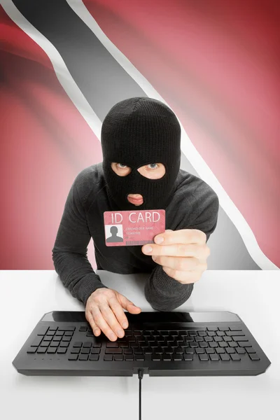 Hacker with flag on background holding ID card in hand - Trinidad and Tobago — Stock Photo, Image