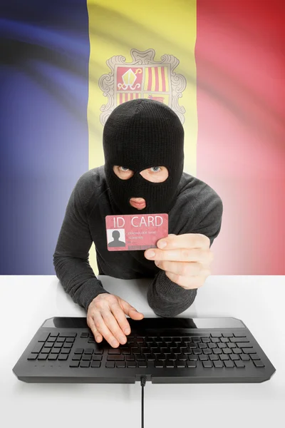 Hacker with flag on background holding ID card in hand - Andorra — Stock Photo, Image