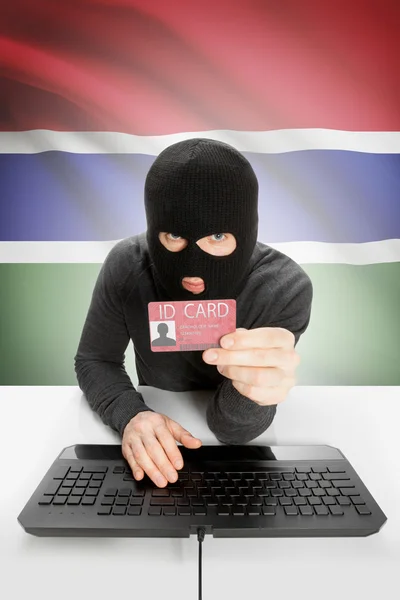 Hacker with flag on background holding ID card in hand - Gambia — Stock Photo, Image