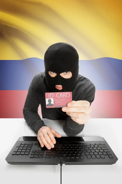 Hacker with flag on background holding ID card in hand - Colombia — Stock Photo, Image