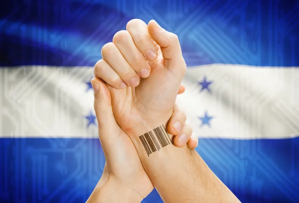 Barcode ID number on wrist and national flag on background - Honduras — Stok fotoğraf