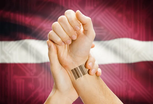 Barcode ID number on wrist and national flag on background - Latvia — Foto Stock