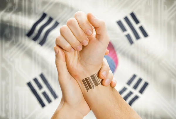 Barcode ID number on wrist and national flag on background - South Korea — Stock Photo, Image
