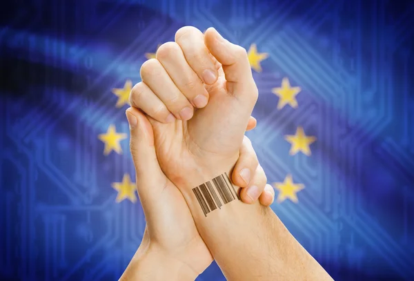 Barcode ID number on wrist and national flag on background - European Union — Stok fotoğraf