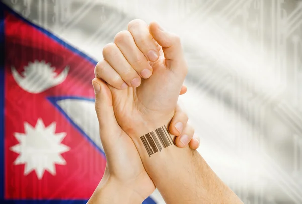 Barcode ID number on wrist and national flag on background - Nepal — Stock Photo, Image
