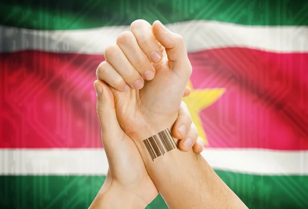 Barcode ID number on wrist and national flag on background - Suriname — Stock Photo, Image