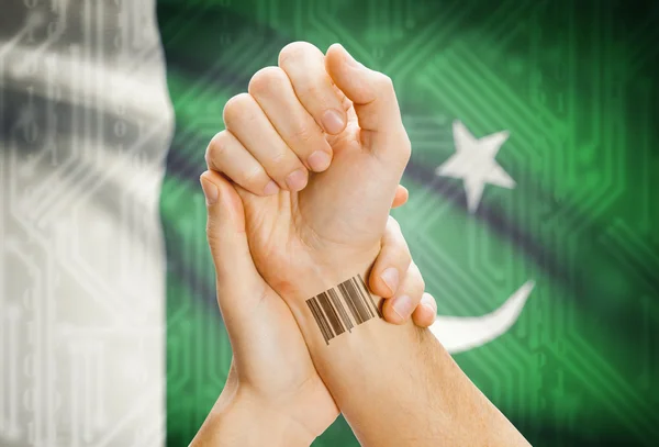 Barcode ID number on wrist and national flag on background - Pakistan — Stock fotografie