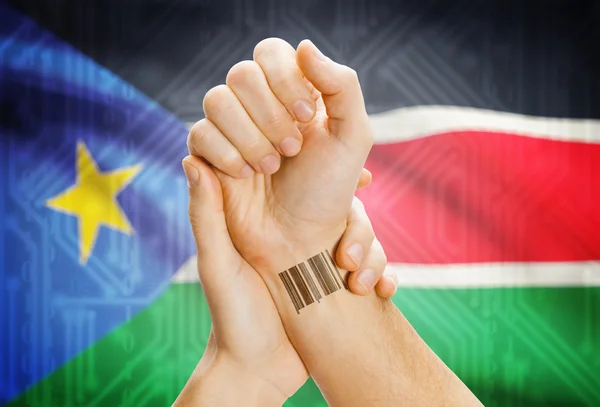 Идентификационный номер штрих-кода на запястье и национальный флаг на фоне - Южный Судан — стоковое фото