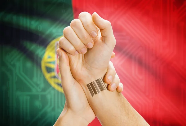 Barcode ID number on wrist and national flag on background - Portugal — Stockfoto