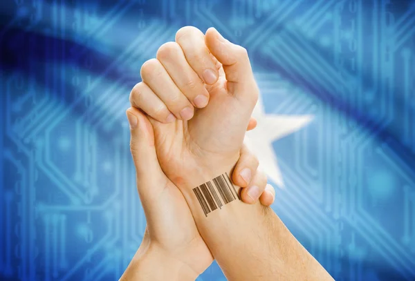 Barcode ID number on wrist and national flag on background - Somalia — Stok fotoğraf