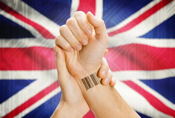 Barcode ID number on wrist and national flag on background - United Kingdom — Stock Photo, Image