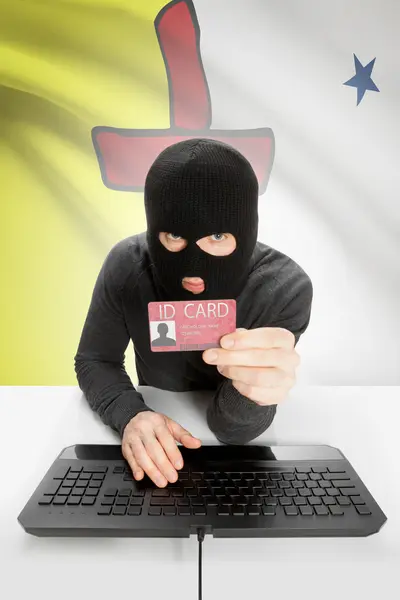 Hacker with Canadian province flag on background holding ID card in hand - Nunavut — Stock fotografie