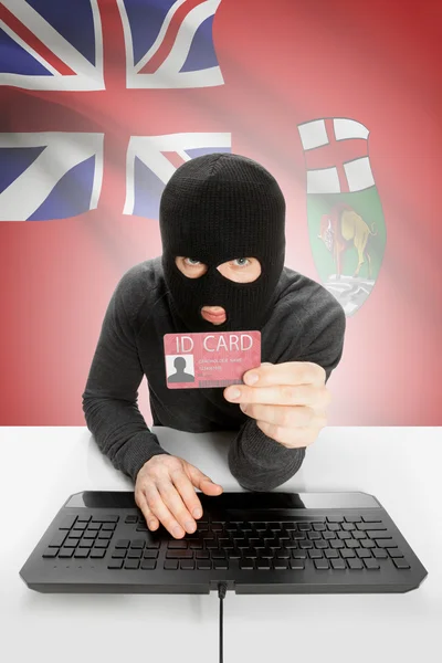 Хакер с канадским флагом провинции на фоне проведения Id карты в руки - Манитоба — стоковое фото