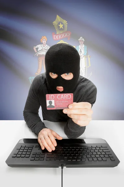 Hacker with USA states flag on background and ID card in hand - Maine — Stok fotoğraf