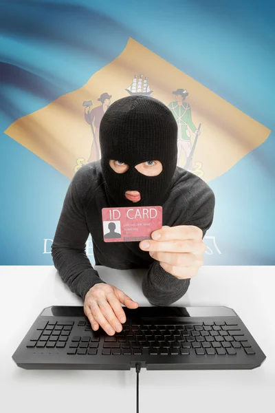 Hacker with USA states flag on background and ID card in hand - Delaware — Stock fotografie