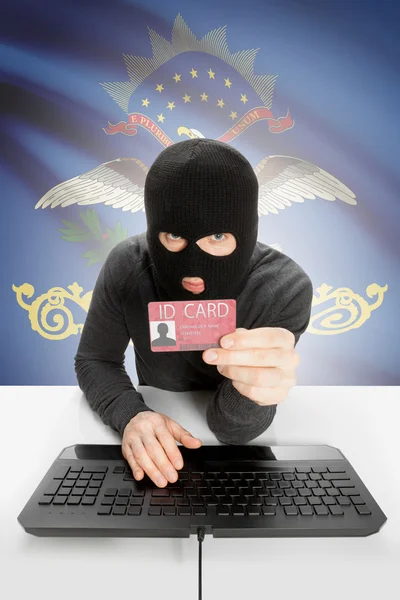 Hacker with USA states flag on background and ID card in hand - North Dakota — Stock Photo, Image