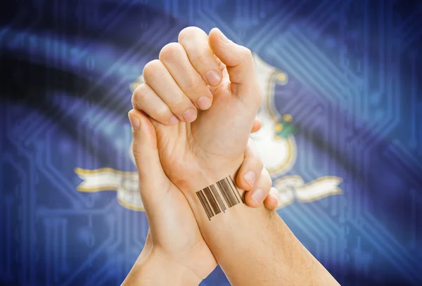 Barcode ID number on wrist and USA states flags on background - Connecticut — 图库照片