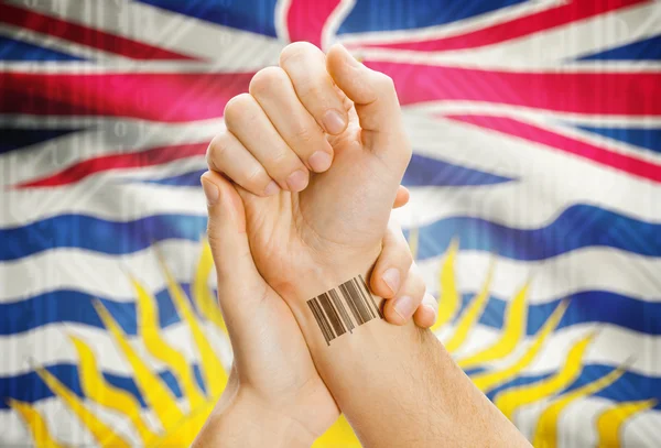 Barcode ID number on wrist with Canadian province flag on background - British Columbia — Stock Photo, Image