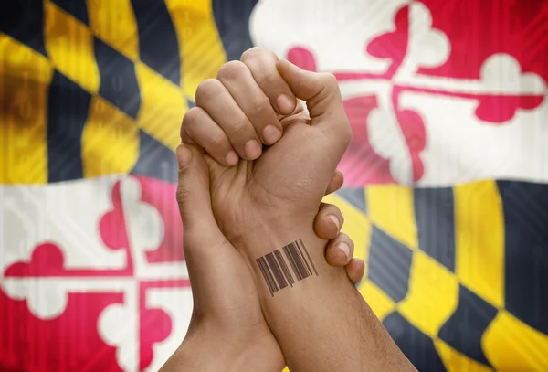 Barcode ID number on wrist of dark skinned person and USA states flags on background - Maryland — Stockfoto