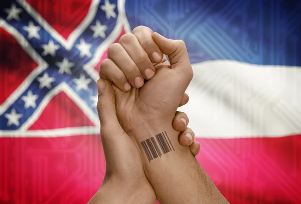 Numéro Barcode Id sur le poignet de la personne à la peau sombre et Usa Etats drapeaux sur fond - Mississippi — Photo