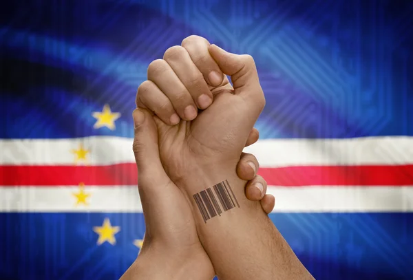 Barcode ID number on wrist of dark skinned person and national flag on background - Cape Verde — ストック写真