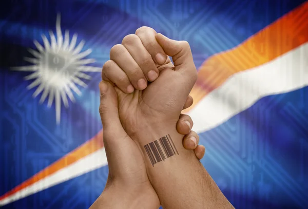 Barcode ID number on wrist of dark skinned person and national flag on background - Marshall Islands — Stock Photo, Image