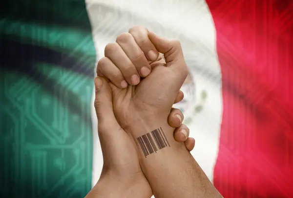 Barcode ID number on wrist of dark skinned person and national flag on background - Mexico — Foto Stock