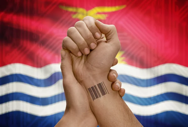 Barcode ID number on wrist of dark skinned person and national flag on background - Kiribati — стокове фото