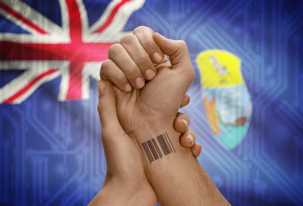 Barcode ID number on wrist of dark skinned person and national flag on background - Saint Helena — Stock Photo, Image