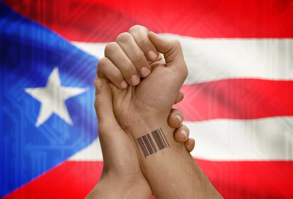 Barcode ID number on wrist of dark skinned person and national flag on background - Puerto Rico — Stock Photo, Image