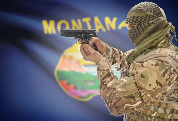 Male in muslim keffiyeh with gun in hand and flag on background - Montana — Stok fotoğraf