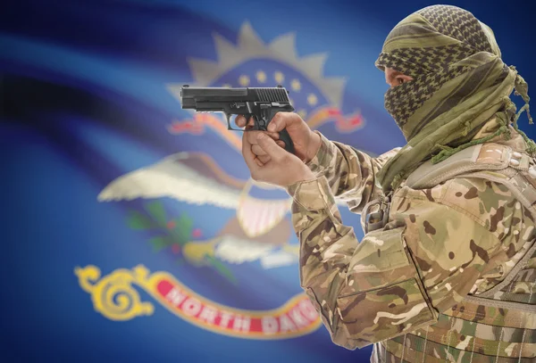 Male in muslim keffiyeh with gun in hand and flag on background - North Dakota — Stok fotoğraf