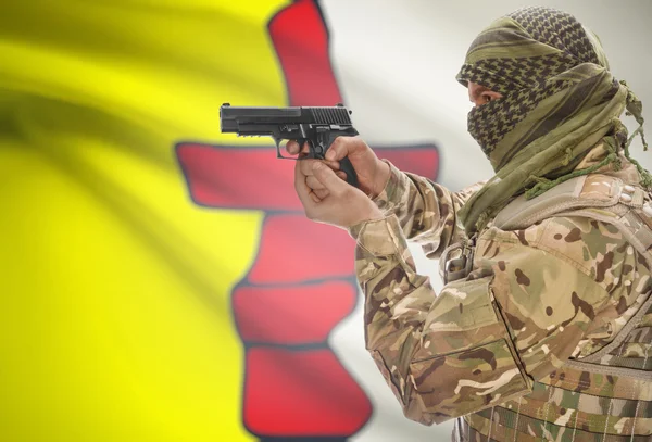 Male in muslim keffiyeh with gun in hand and Canadian province flag on background - Nunavut — стокове фото