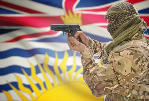 Male in muslim keffiyeh with gun in hand and Canadian province flag on background - British Columbia — 图库照片