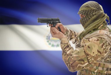 Male in muslim keffiyeh with gun in hand and national flag on background - El Salvador
