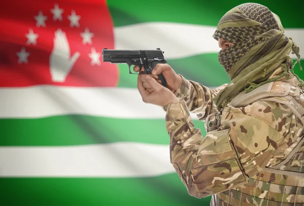 Male in muslim keffiyeh with gun in hand and national flag on background - Abkhazia — Stock Fotó