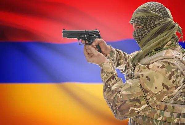 Male in muslim keffiyeh with gun in hand and national flag on background - Armenia — Stok fotoğraf