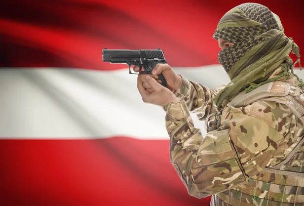 Мужчина в мусульманскую куфия с пистолетом в руке и национальный флаг на фоне - Австрия — стоковое фото