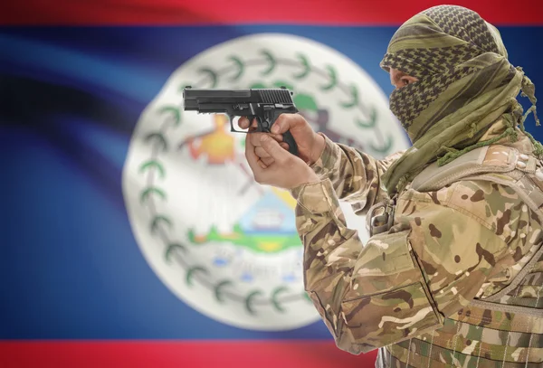 Male in muslim keffiyeh with gun in hand and national flag on background - Belize — стокове фото